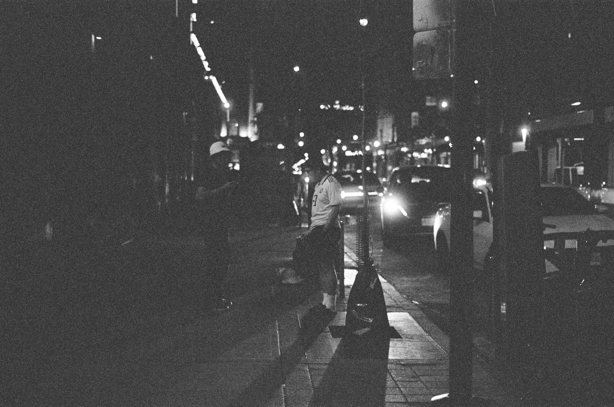 A dark street with distant headlights
