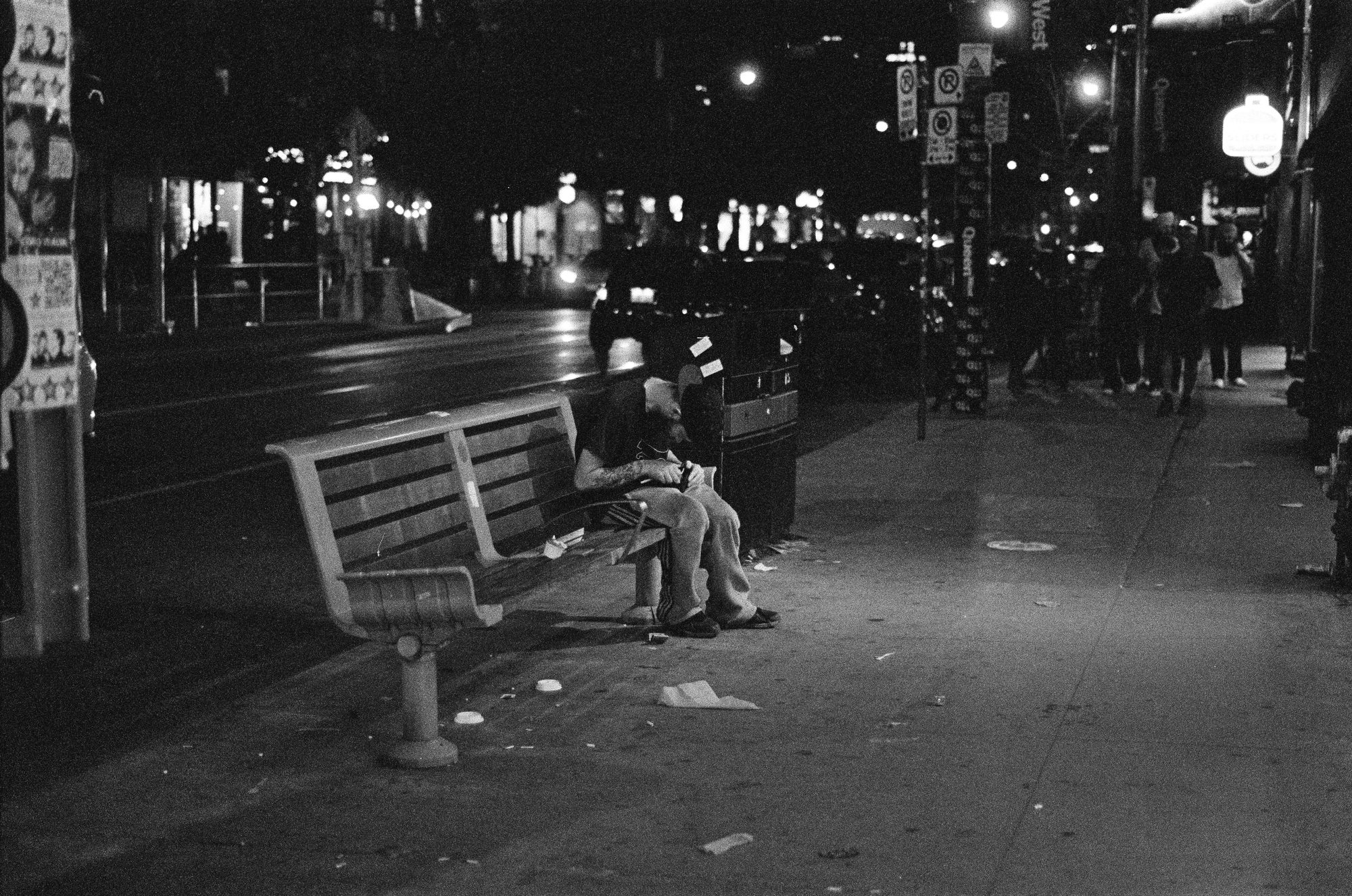 A person alone on a bench on an emptying street