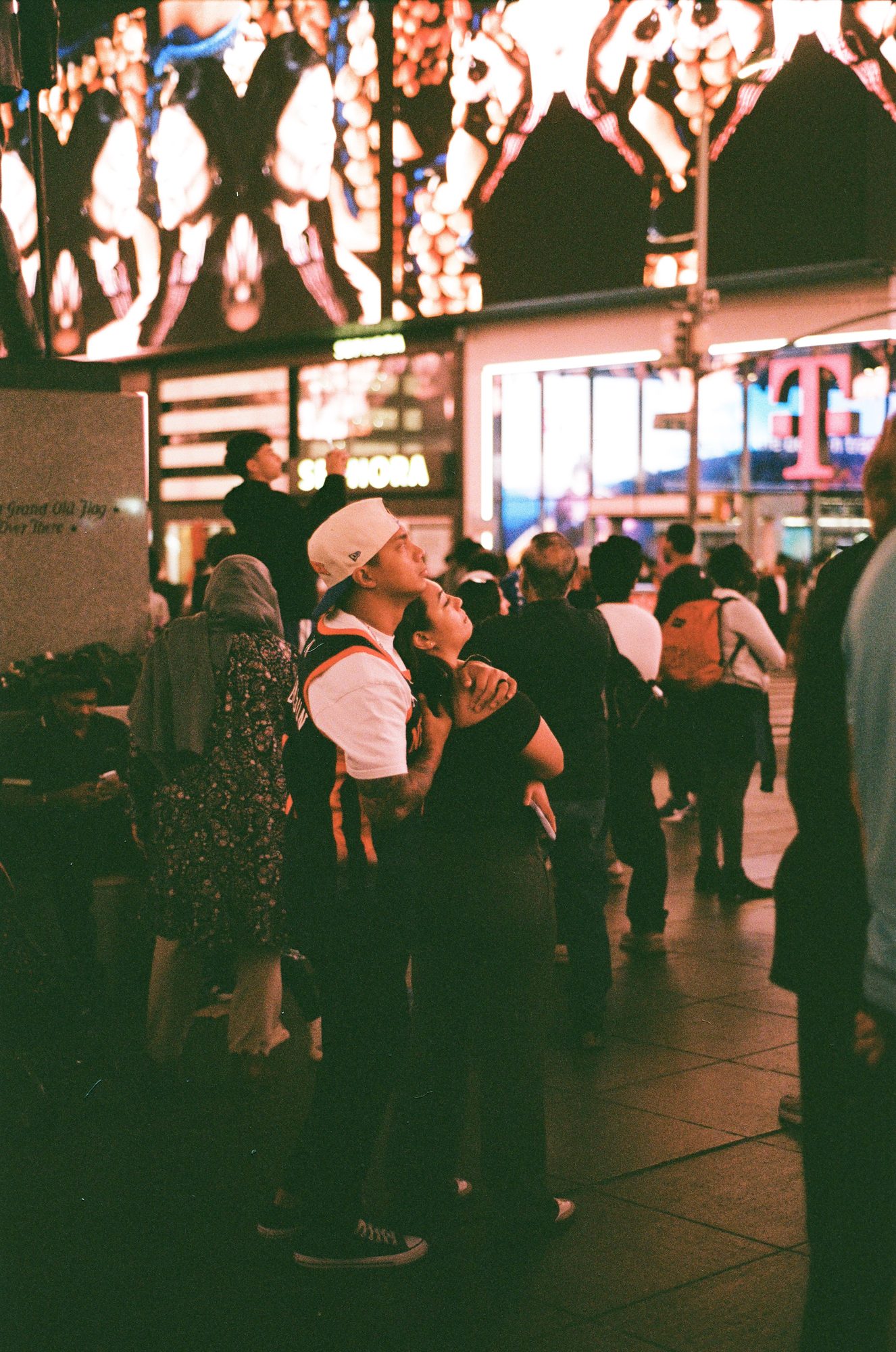 A crowd beneath giant video screens