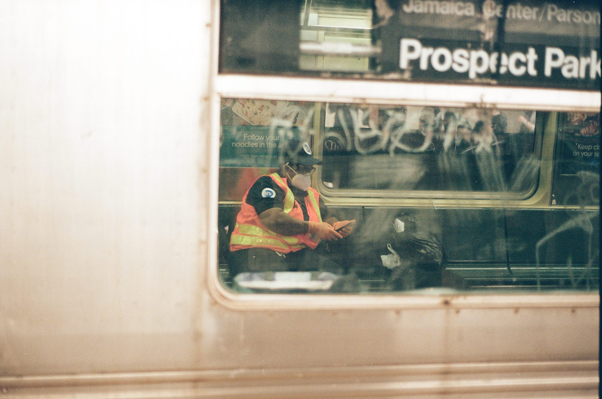 A subway car window sliding past, Prospect Park on the sign