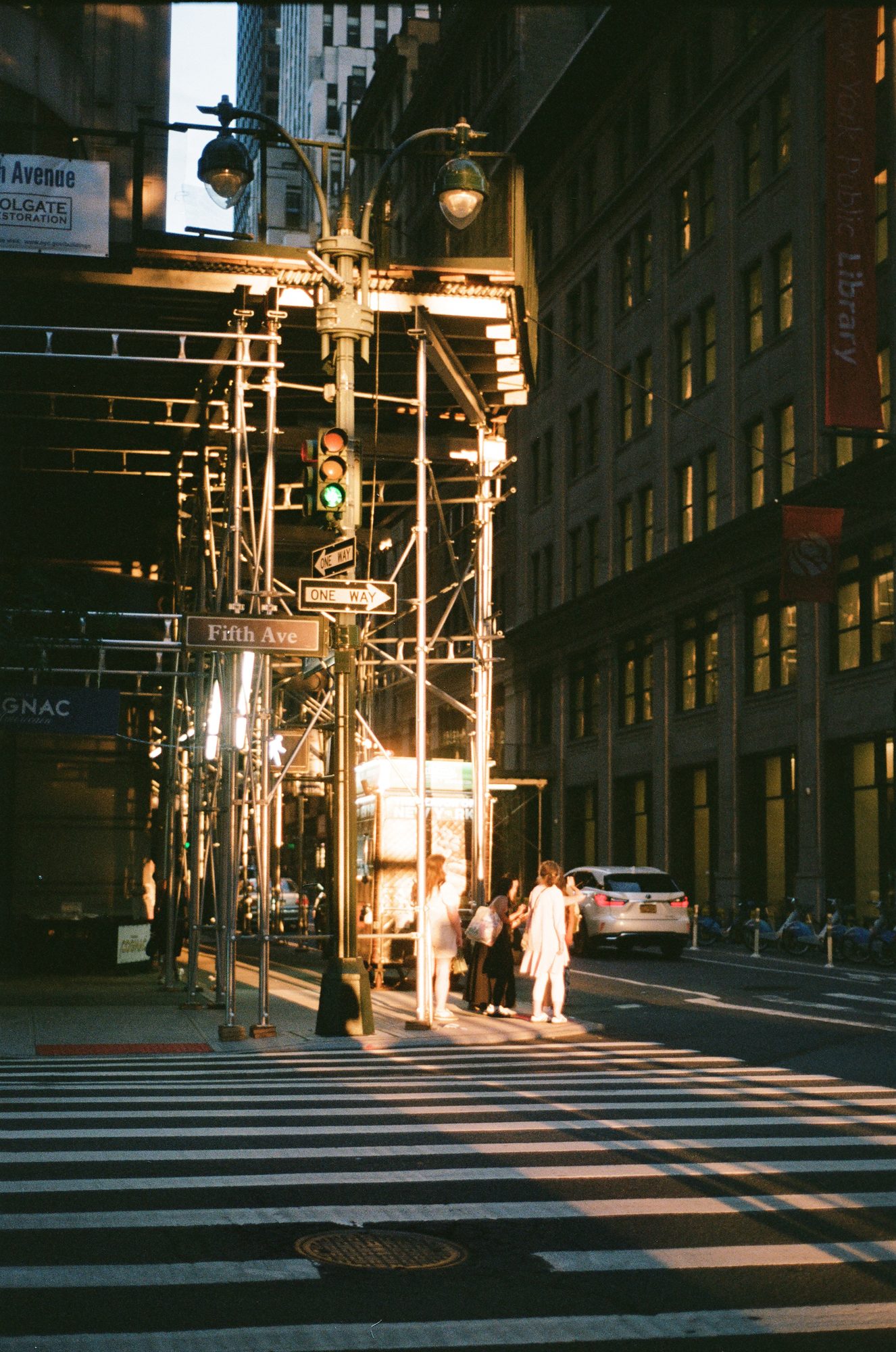 Late light raking across scaffolding and a crosswalk