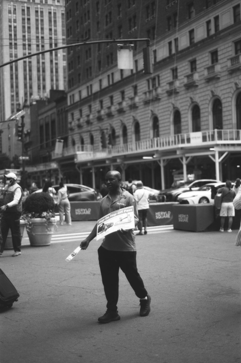 A man handing out hop-on hop-off flyers in Herald Square
