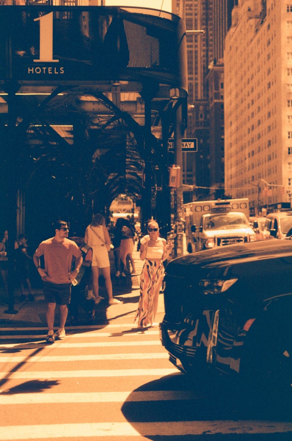 Pedestrians crossing beneath a building canopy