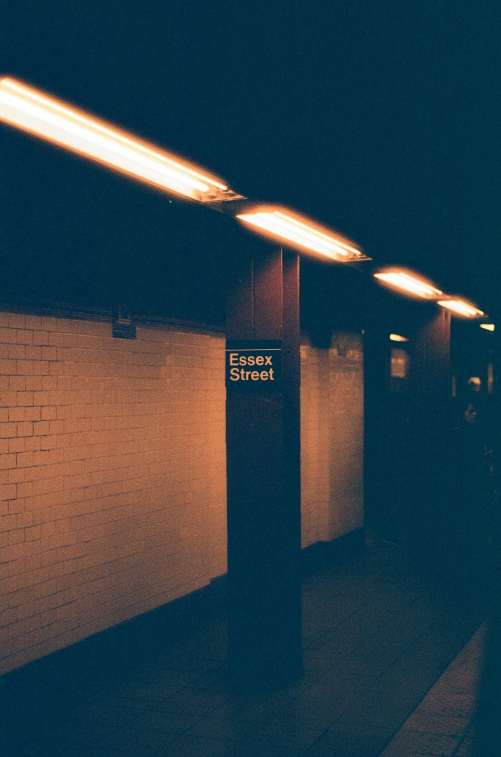 Strip lights over a subway platform and its station sign