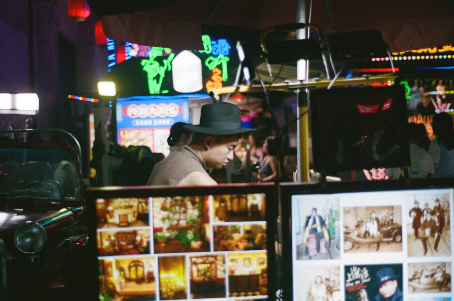 A vendor behind a cart of glowing menu pictures