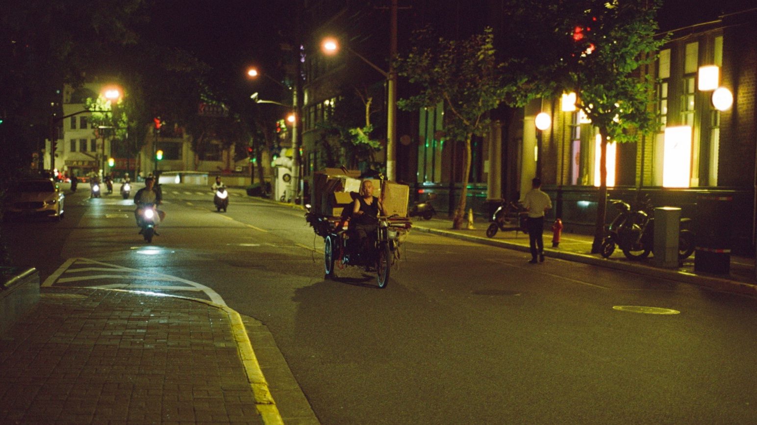 A night street with scooters and lit shopfronts