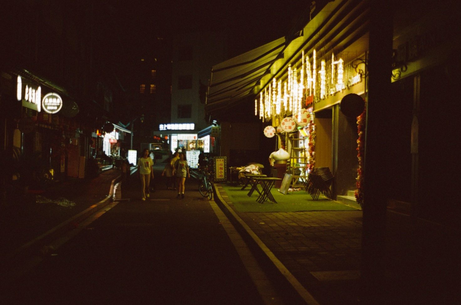 A quiet lane beside a lantern-lit restaurant