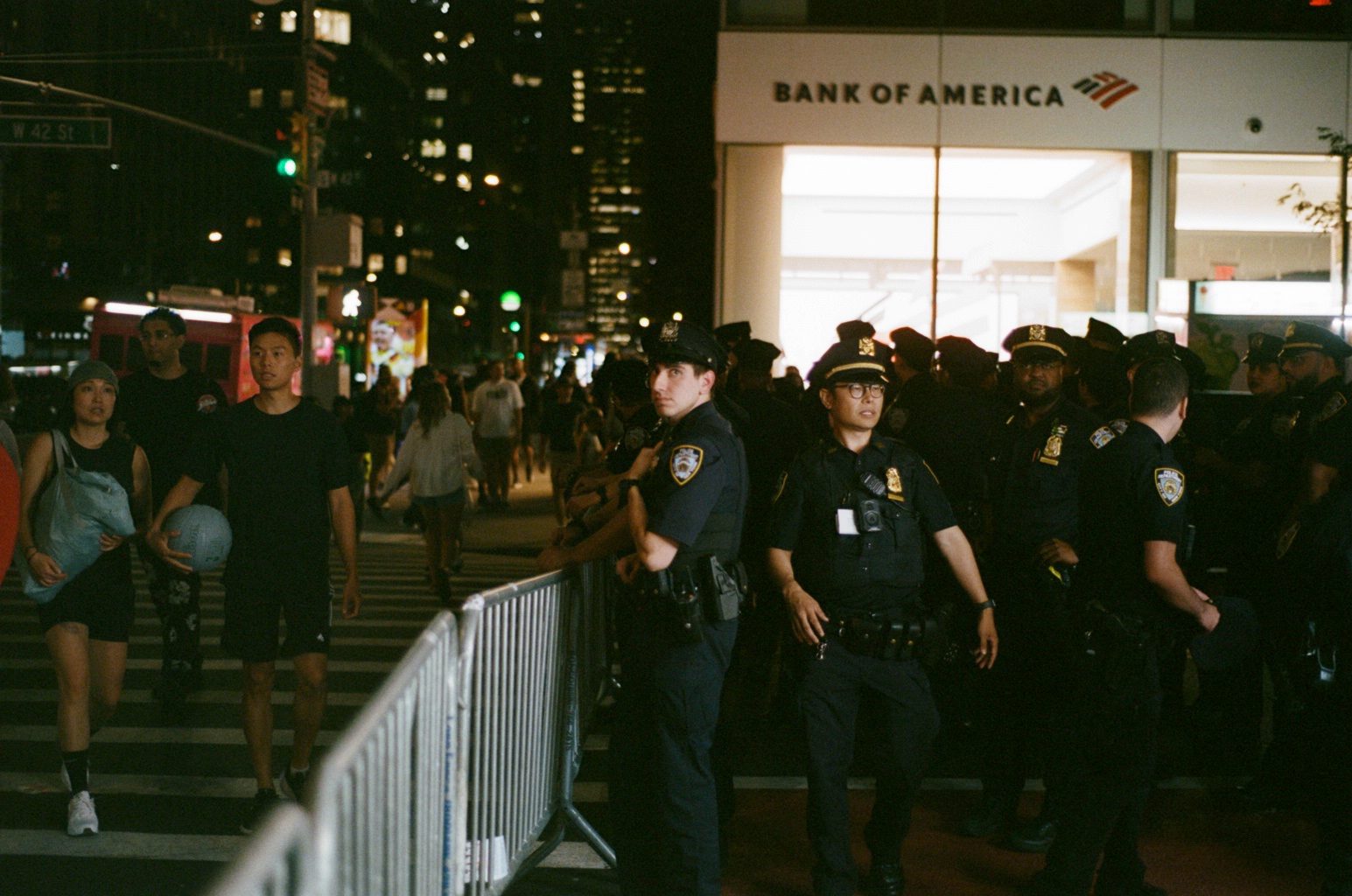 A police line beside metal barricades under a Bank of America sign