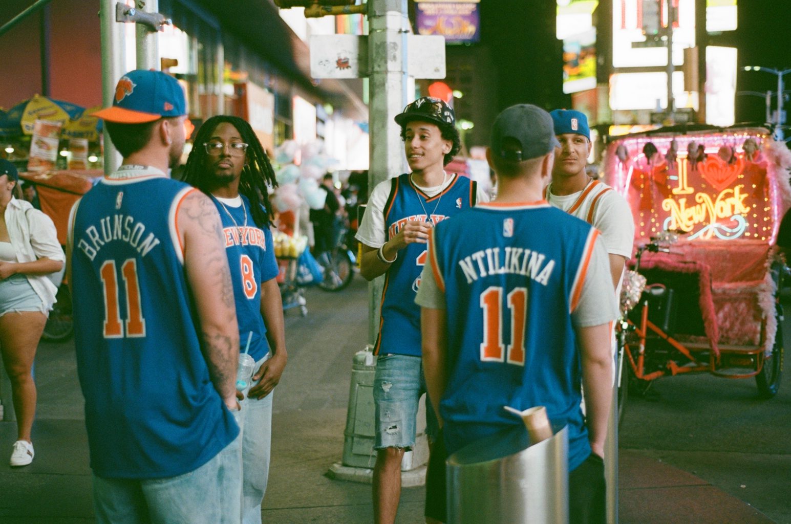 Fans in Brunson and Ntilikina Knicks jerseys on a Times Square sidewalk