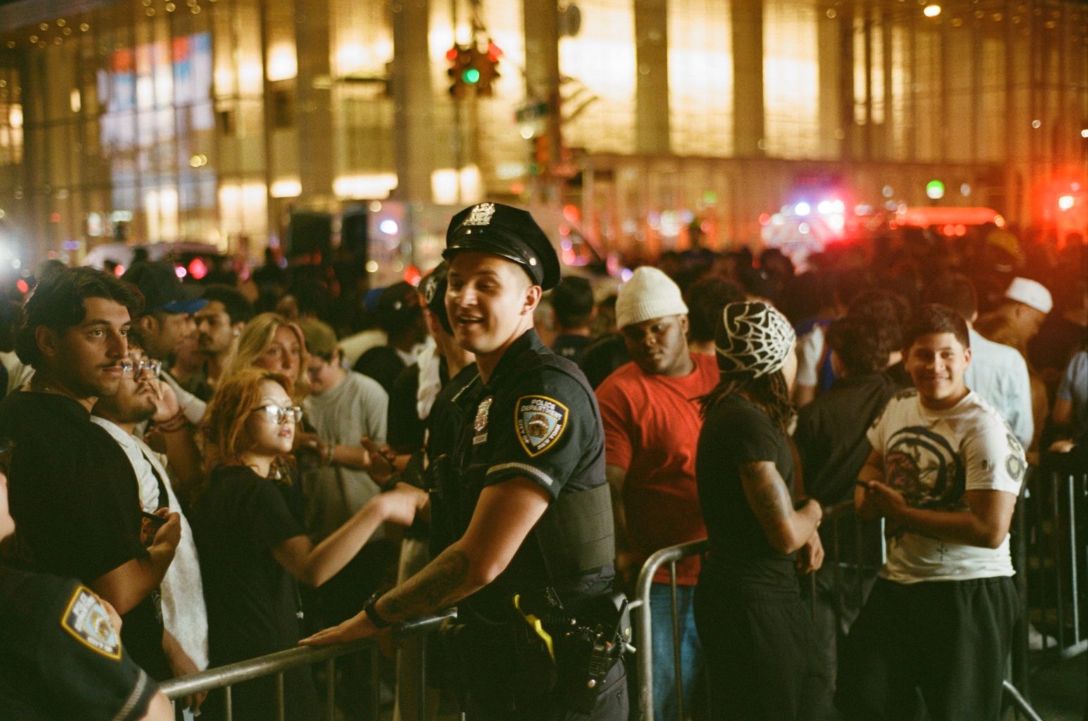 A police officer grinning alongside fans at the barricade